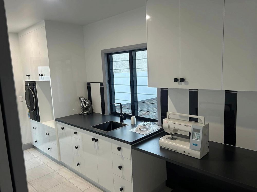 A Kitchen With White Cabinets And A Sewing Machine On The Counter — Pioneer Cabinets in Paget, QLD