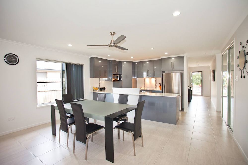 A Kitchen With A Table And Chairs And A Ceiling Fan — Pioneer Cabinets in Paget, QLD