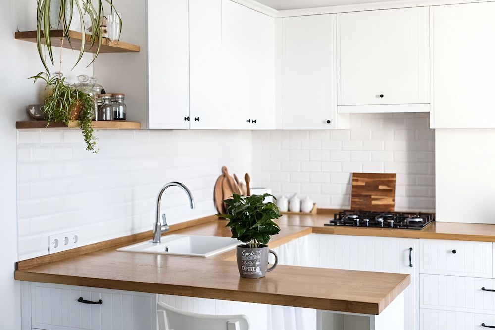 A Kitchen With White Cabinets And A Wooden Countertop — Pioneer Cabinets in Paget, QLD