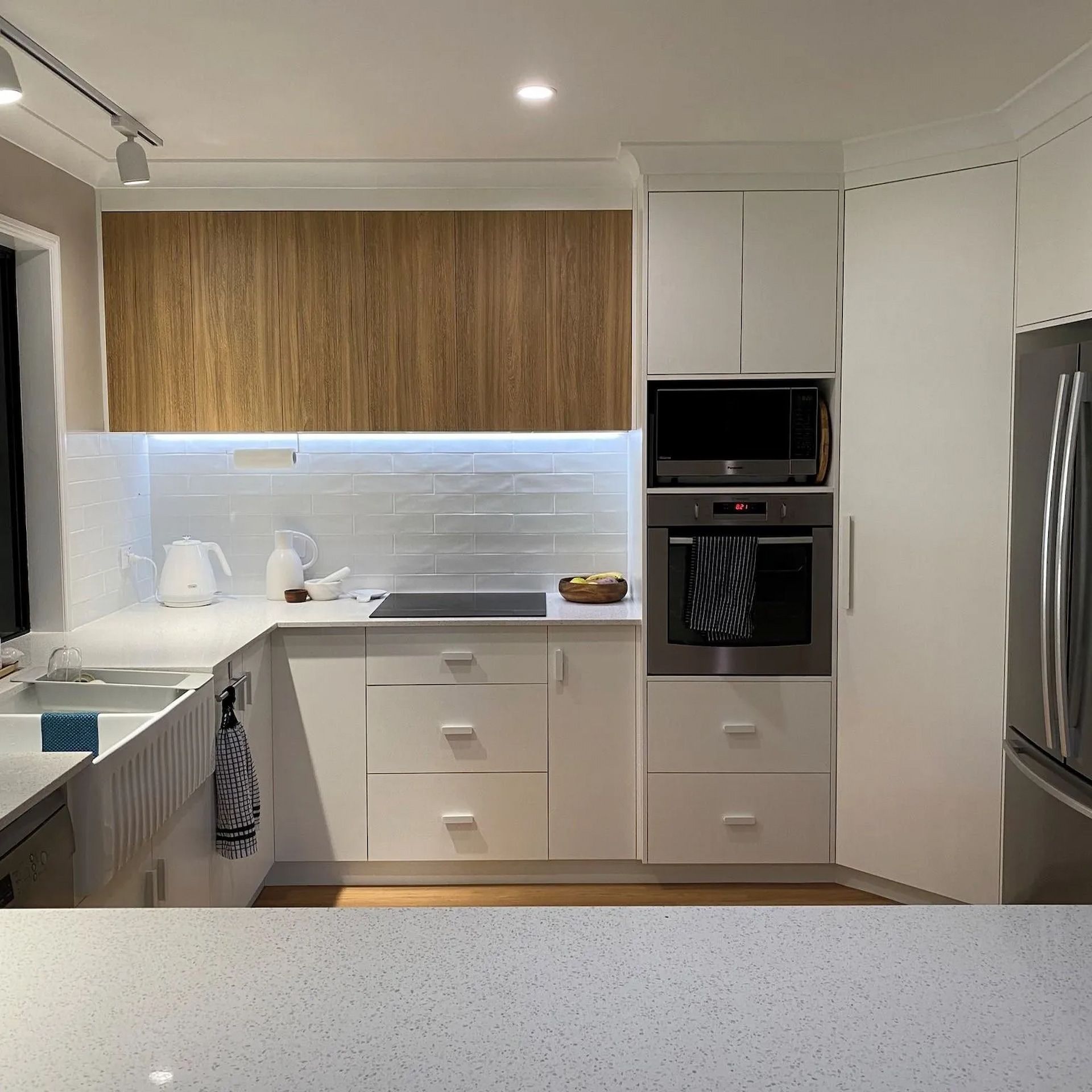 A Kitchen With White Cabinets And Stainless Steel Appliances — Pioneer Cabinets in Paget, QLD
