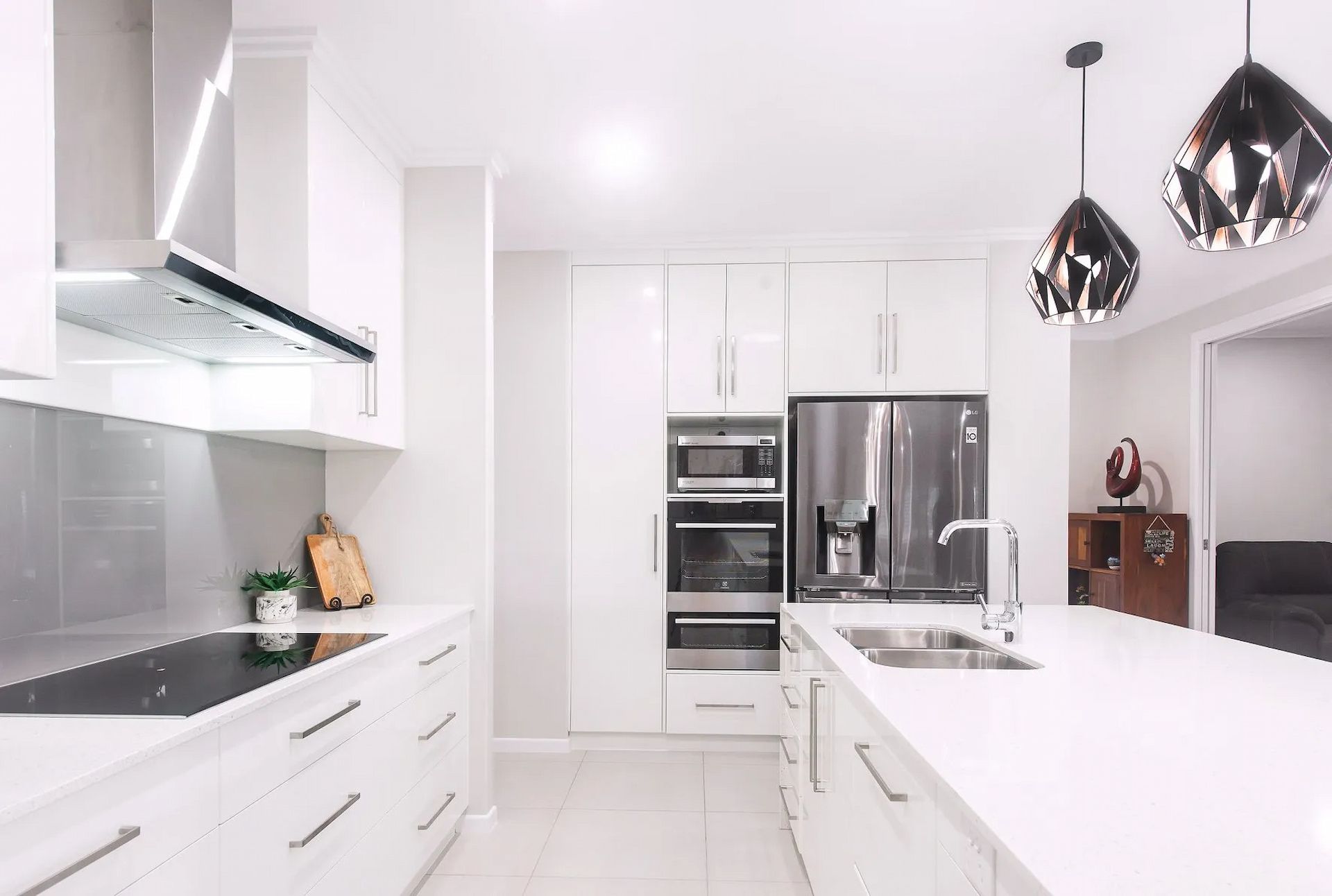 A Kitchen With White Cabinets And Appliances — Pioneer Cabinets in Paget, QLD
