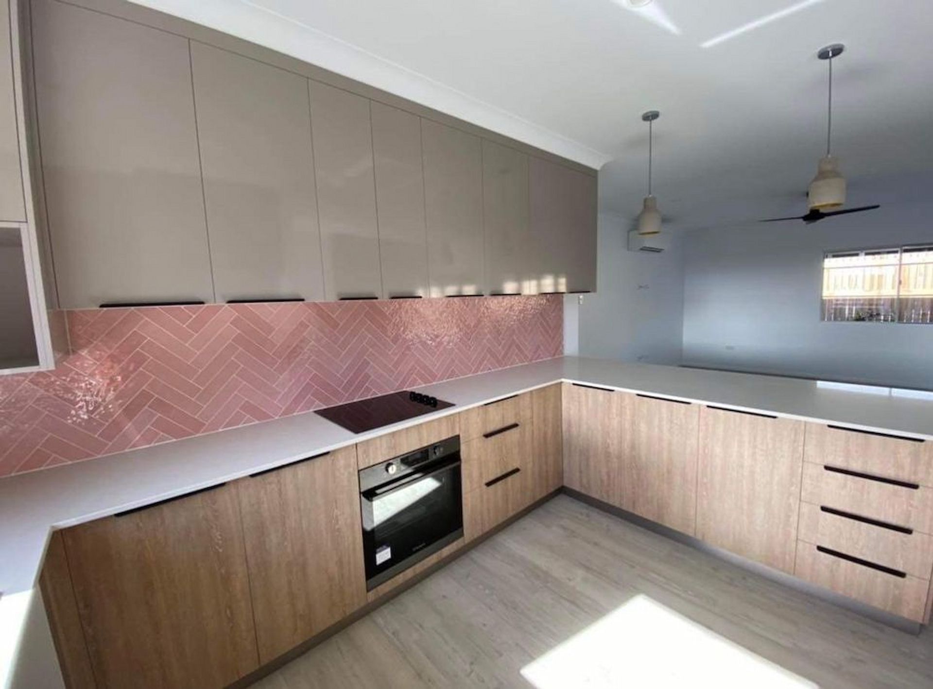 A Kitchen With Wooden Cabinets And A Pink Tile Backsplash — Pioneer Cabinets in Paget, QLD