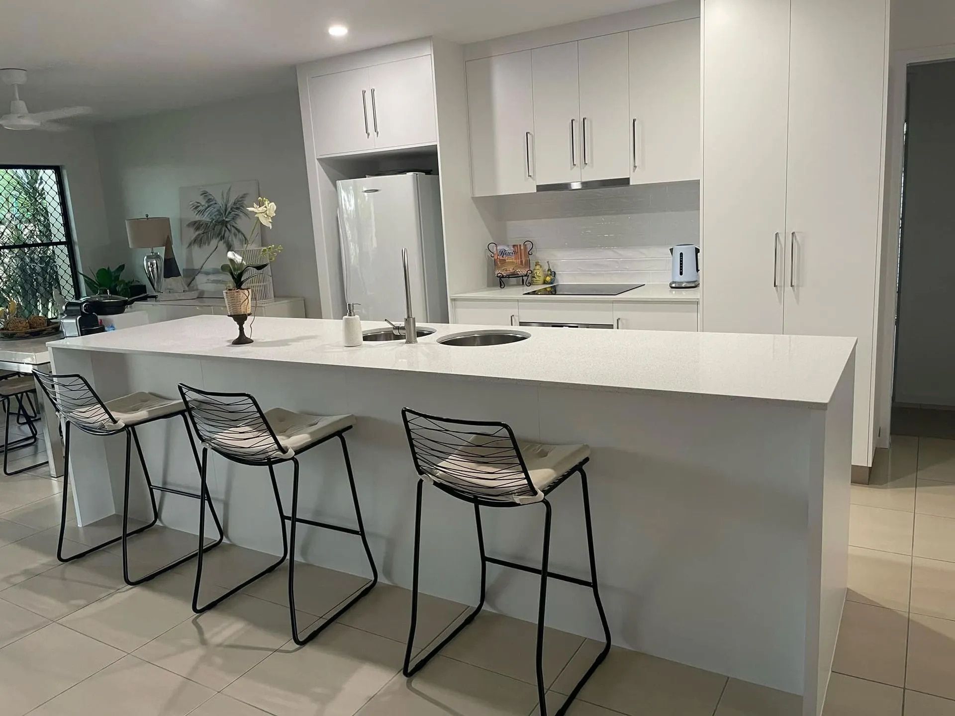 A Kitchen With White Cabinets And Stools — Pioneer Cabinets in Paget, QLD