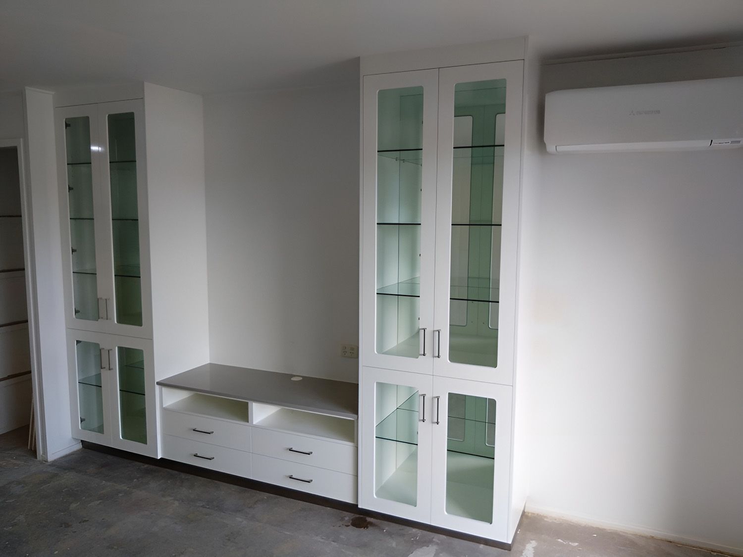 White Built-In Cabinetry With Glass Doors And Shelves