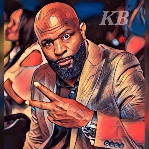 A man with a beard is wearing a suit and giving the peace sign