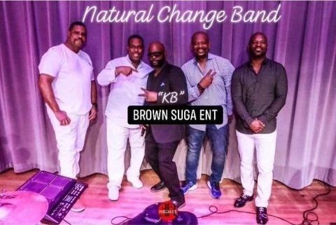 A group of men are posing for a picture in front of a purple curtain.