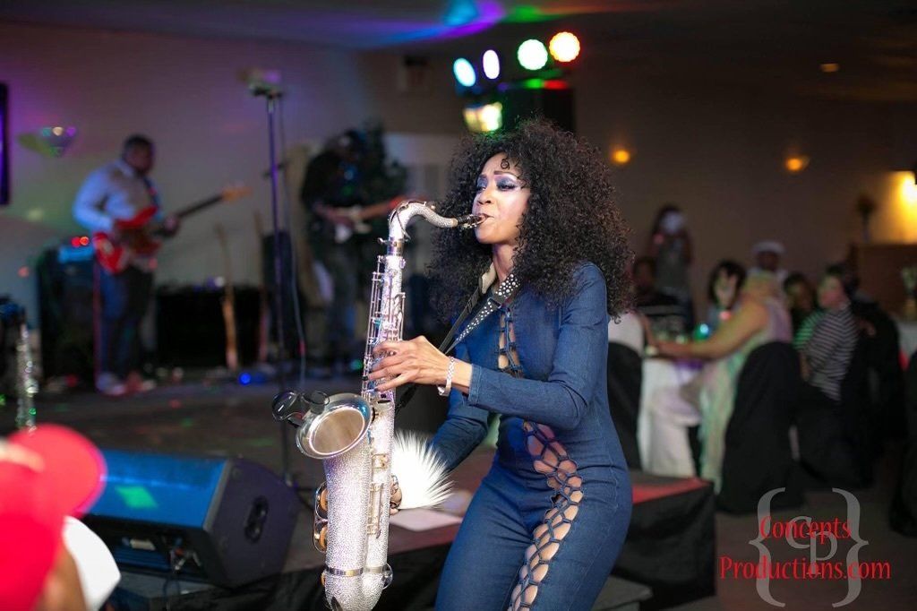 A woman is playing a saxophone on a stage.
