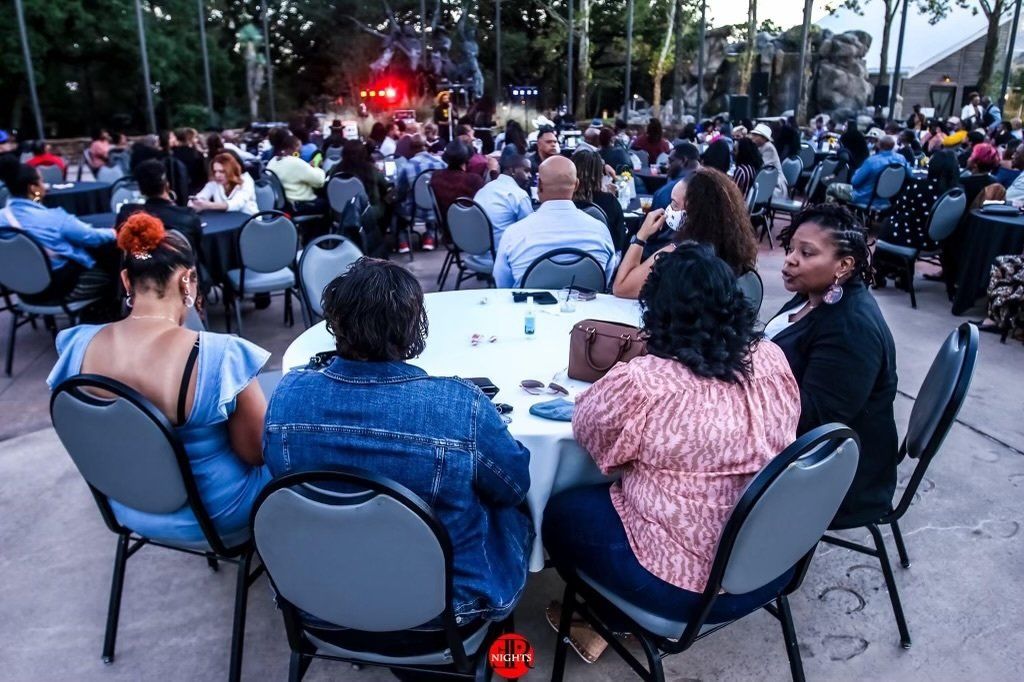 A group of people are sitting around a table at a concert.