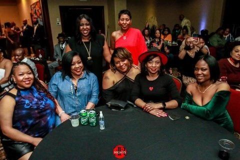 A group of women are sitting around a table at a party.