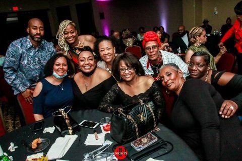 A group of people are posing for a picture at a table.