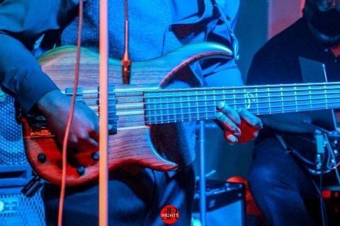 A man is playing a guitar in front of a microphone