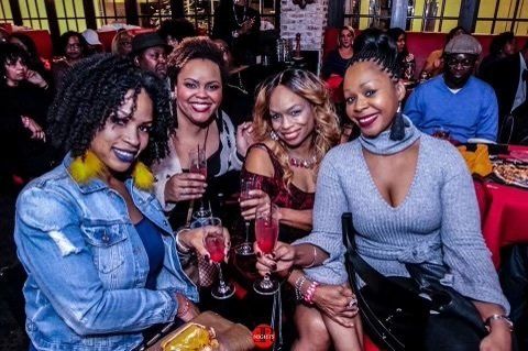 A group of women are sitting at a table holding champagne glasses.
