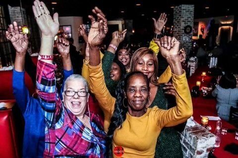 A group of women are raising their hands in the air.