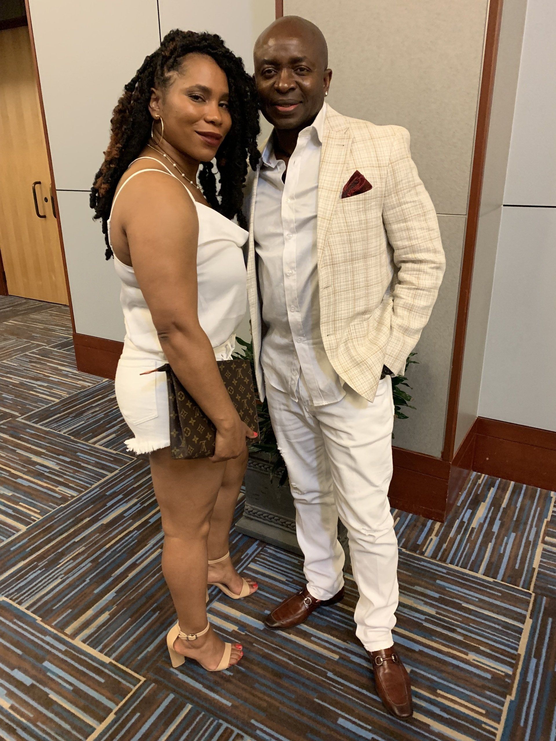 A man and a woman are posing for a picture in a room.