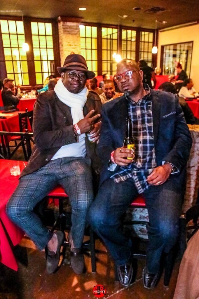 Two men are sitting next to each other in a restaurant.