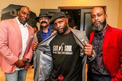 A group of men are posing for a picture and one of them is wearing a shirt that says six soul