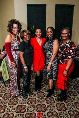 A group of women are posing for a picture together in a room.