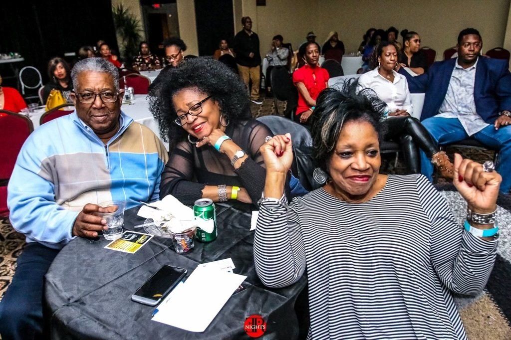 A group of people are sitting at a table in a room.