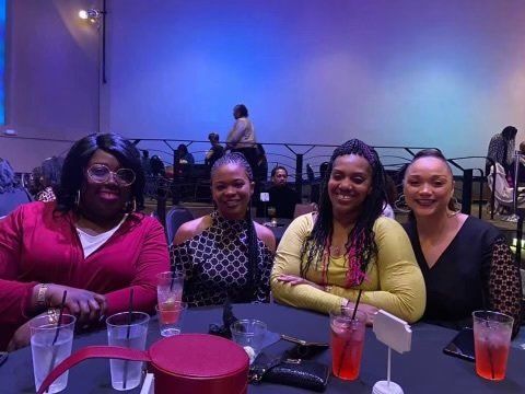 A group of women are sitting at a table with drinks.