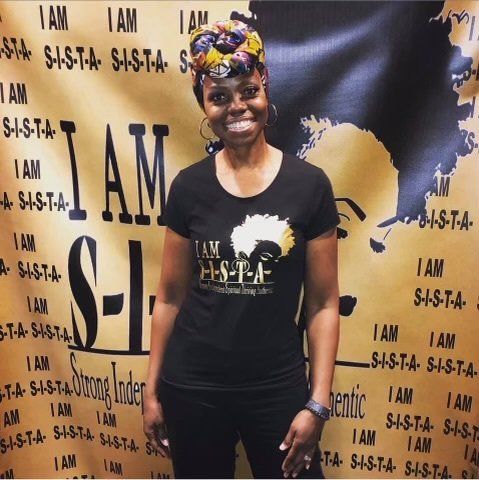 A woman wearing a black shirt that says i am s-i