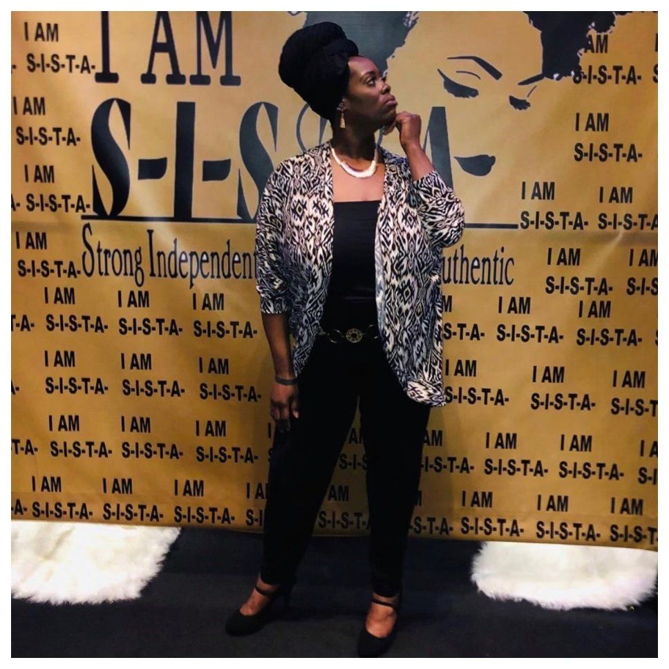 A woman stands in front of a sign that says i am strong independent