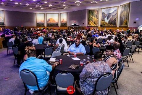 A large group of people are sitting at tables in a large room.
