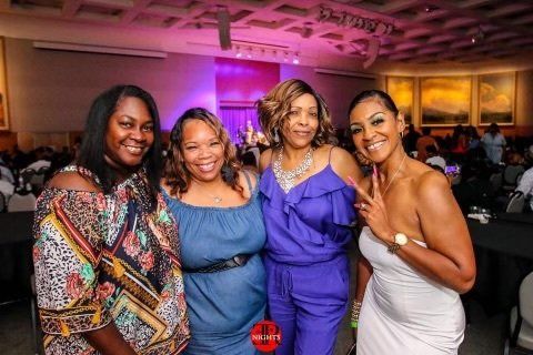 A group of women are posing for a picture in a room.