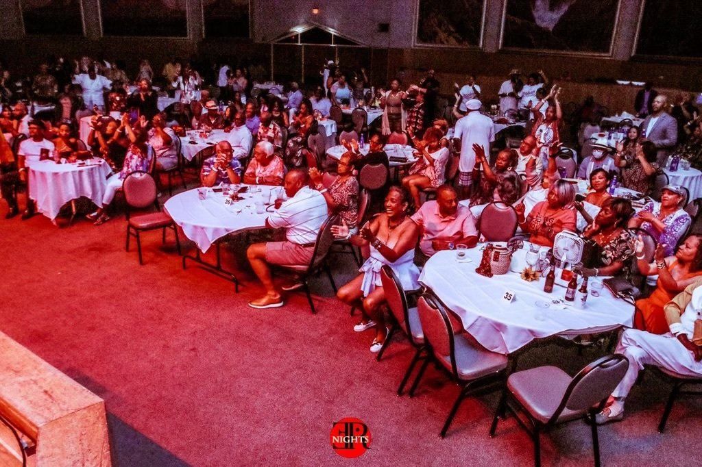 A large group of people are sitting at tables in a large room.