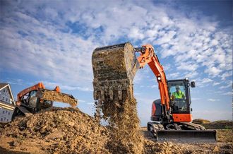 A man is driving an excavator on a construction site.