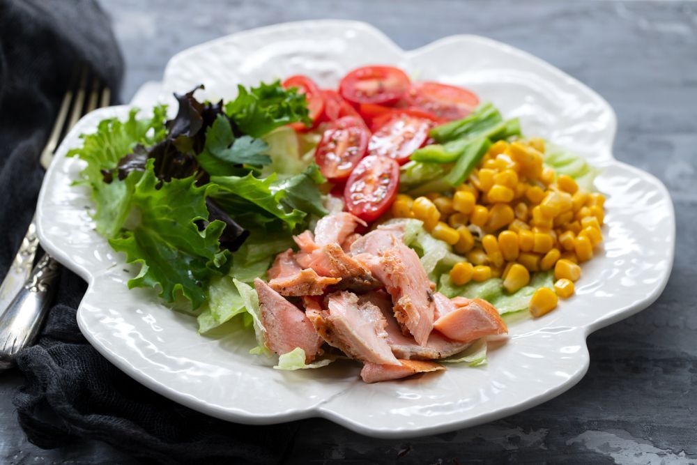 Salmon Salad with Lettuce, Tomatoes, Corn on A White Decorative Plate — Mount Louisa Snack Bar in Mount Louisa, QLD