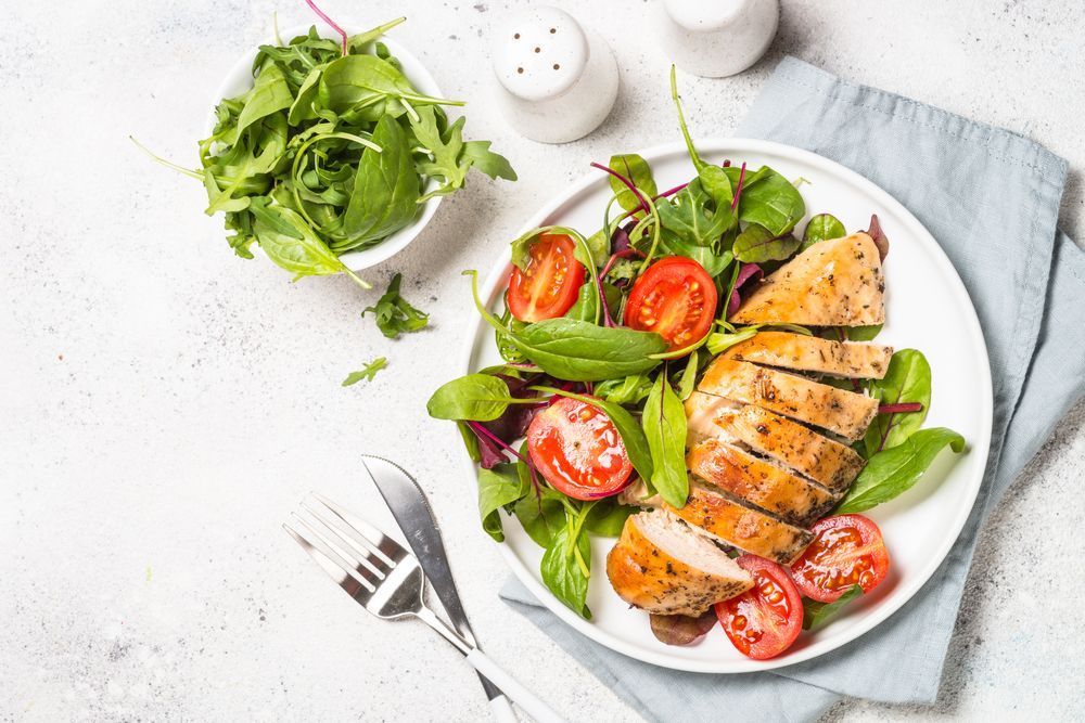 Plate of Sliced Chicken Breast with Salad and Tomatoes — Mount Louisa Snack Bar in Mount Louisa, QLD