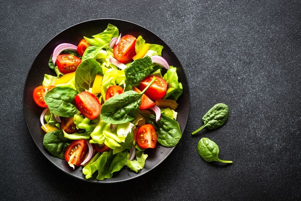Salad on Black Plate: Lettuce, Spinach and Cherry Tomatoes — Mount Louisa Snack Bar in Mount Louisa, QLD