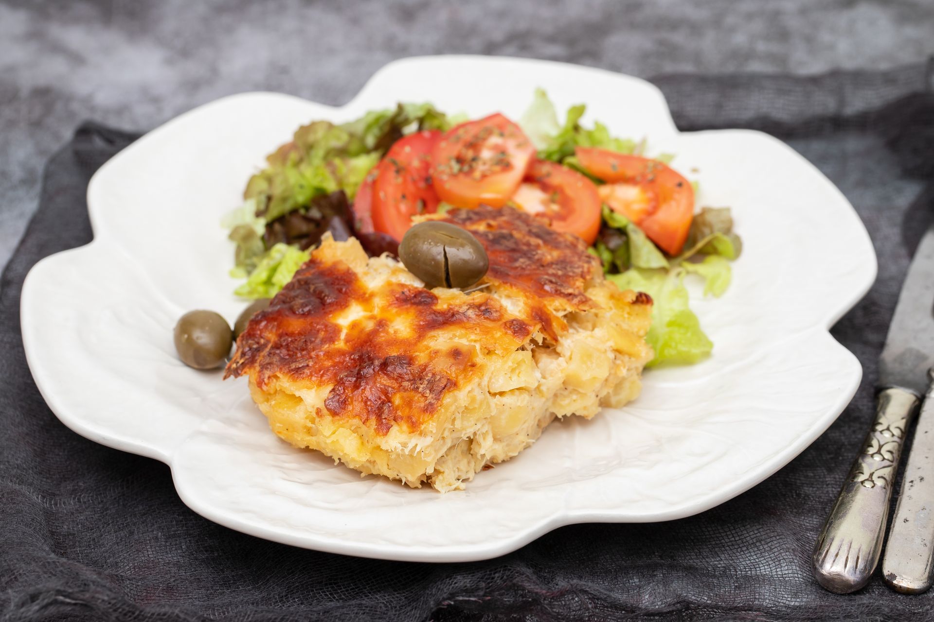 Baked Fish with Salad and Tomatoes on A White Floral Plate — Mount Louisa Snack Bar in Mount Louisa, QLD
