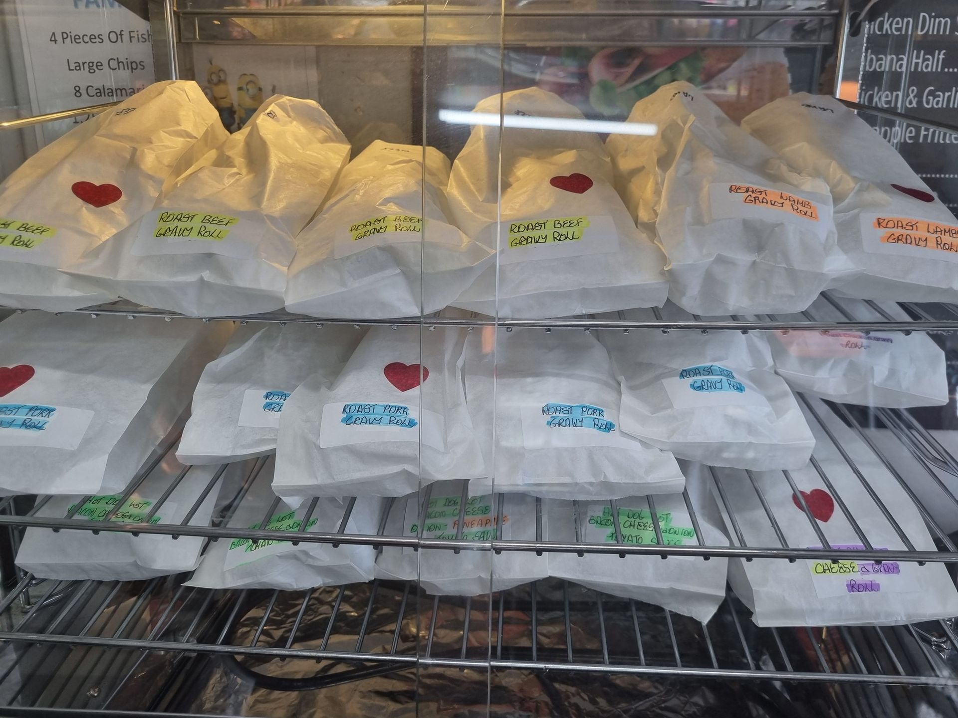 Display Case Filled with White Paper Bags, Many Labeled with Heart Stickers — Mount Louisa Snack Bar in Mount Louisa, QLD