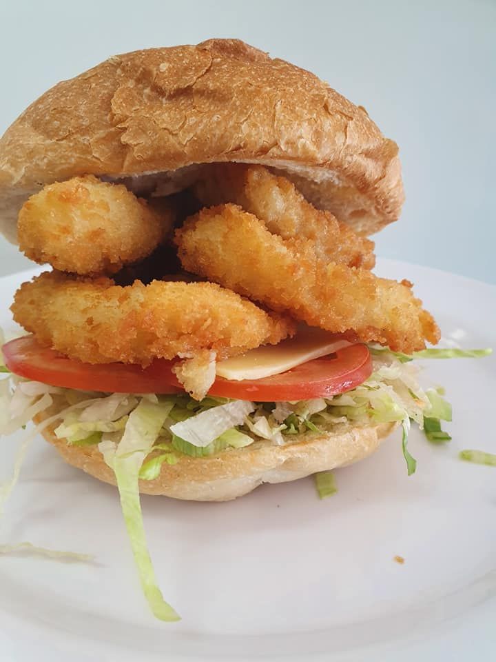 Sandwich with Fried Onion Rings, Tomato, Cheese on A White Plate — Mount Louisa Snack Bar in Mount Louisa, QLD
