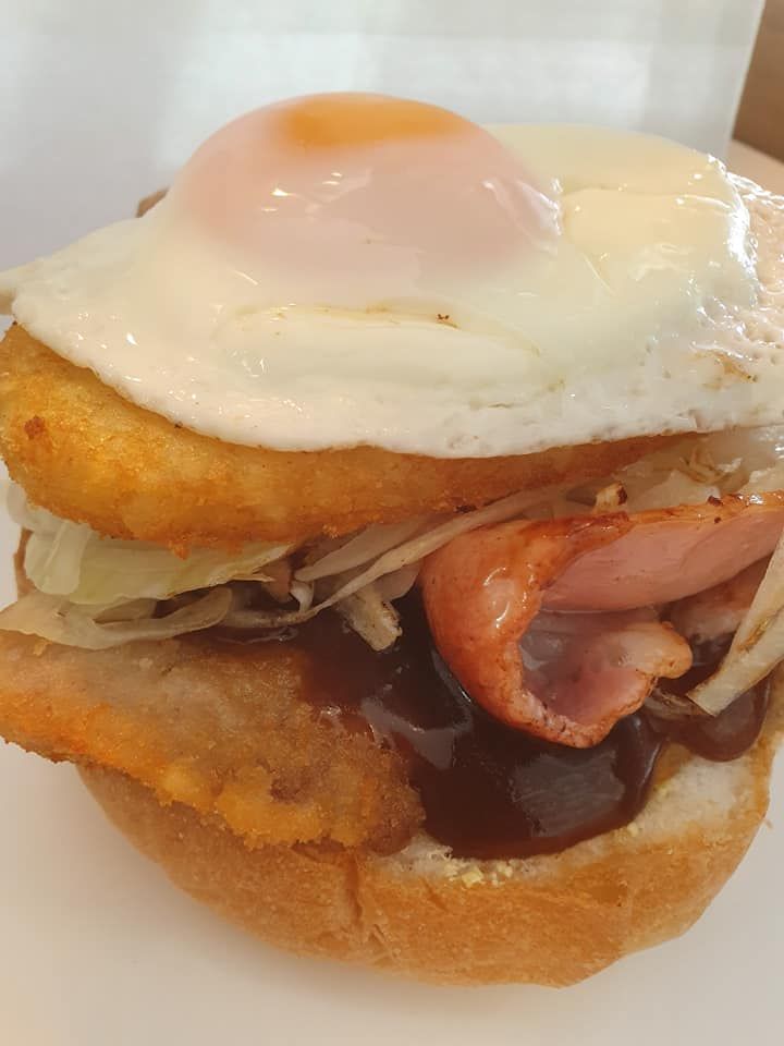 Burger with Fried Egg, Hash Brown, Bacon, Shredded Lettuce and Sauce — Mount Louisa Snack Bar in Mount Louisa, QLD