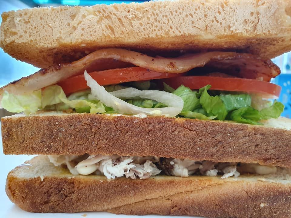 A Layered Sandwich with Chicken, Bacon, Tomato, Lettuce, and Mayonnaise — Mount Louisa Snack Bar in Mount Louisa, QLD