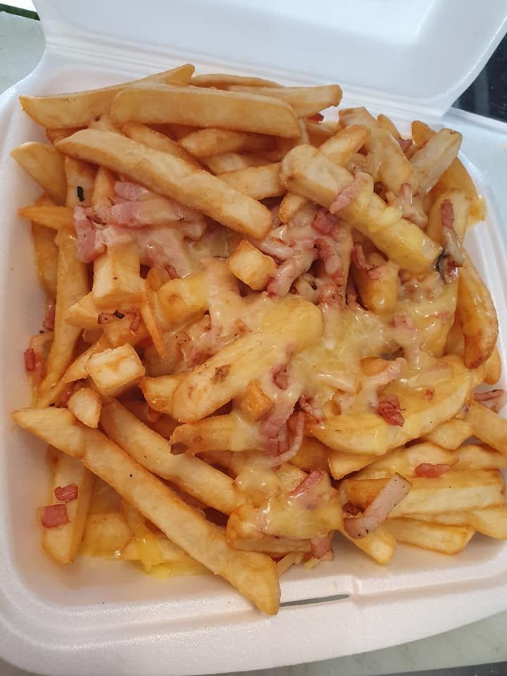 Fries Topped with Melted Cheese and Bacon Bits in A White Container — Mount Louisa Snack Bar in Mount Louisa, QLD