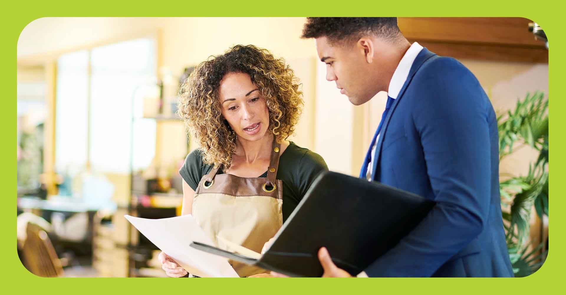 A female business owner looking over books and paperwork with an accountant.