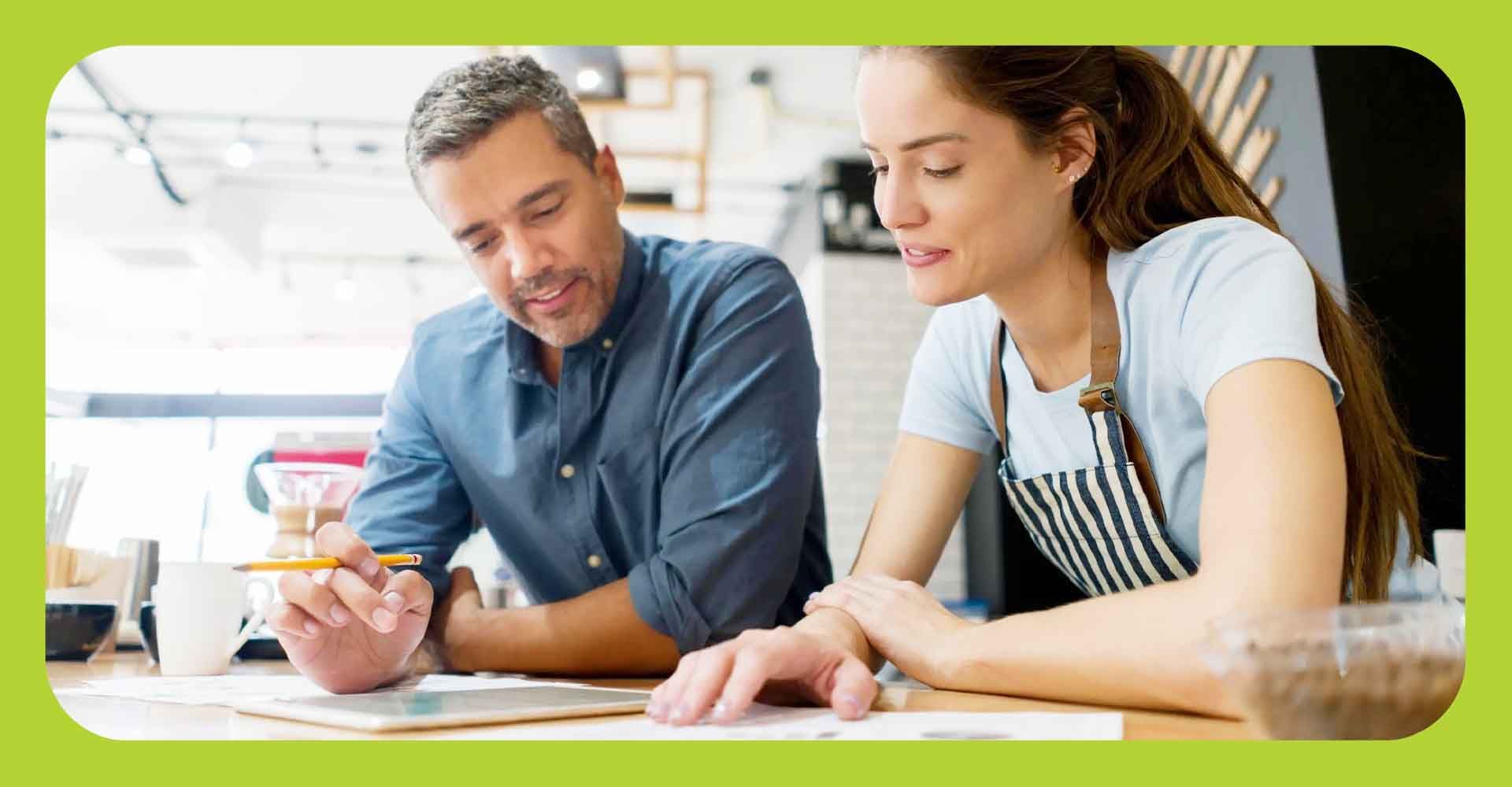 Man and woman looking over paperwork in a work setting