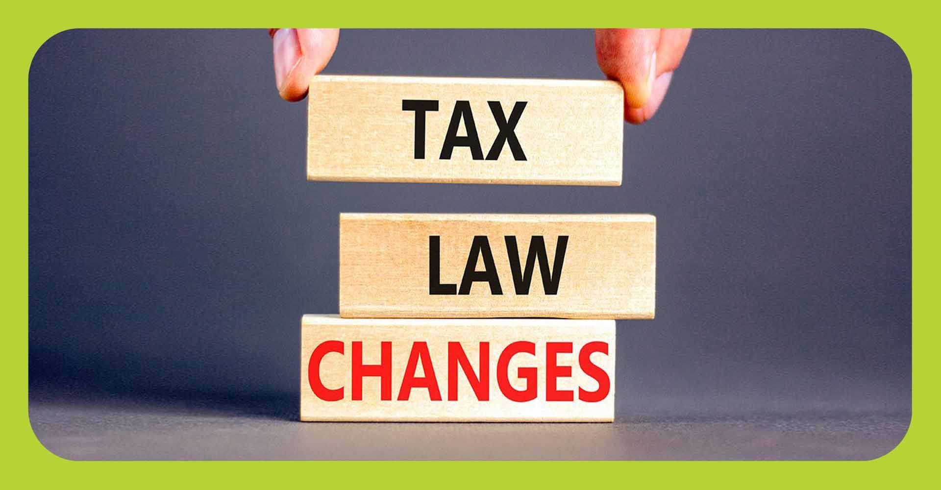 Wooden blocks being stacked that read: tax, law, changes