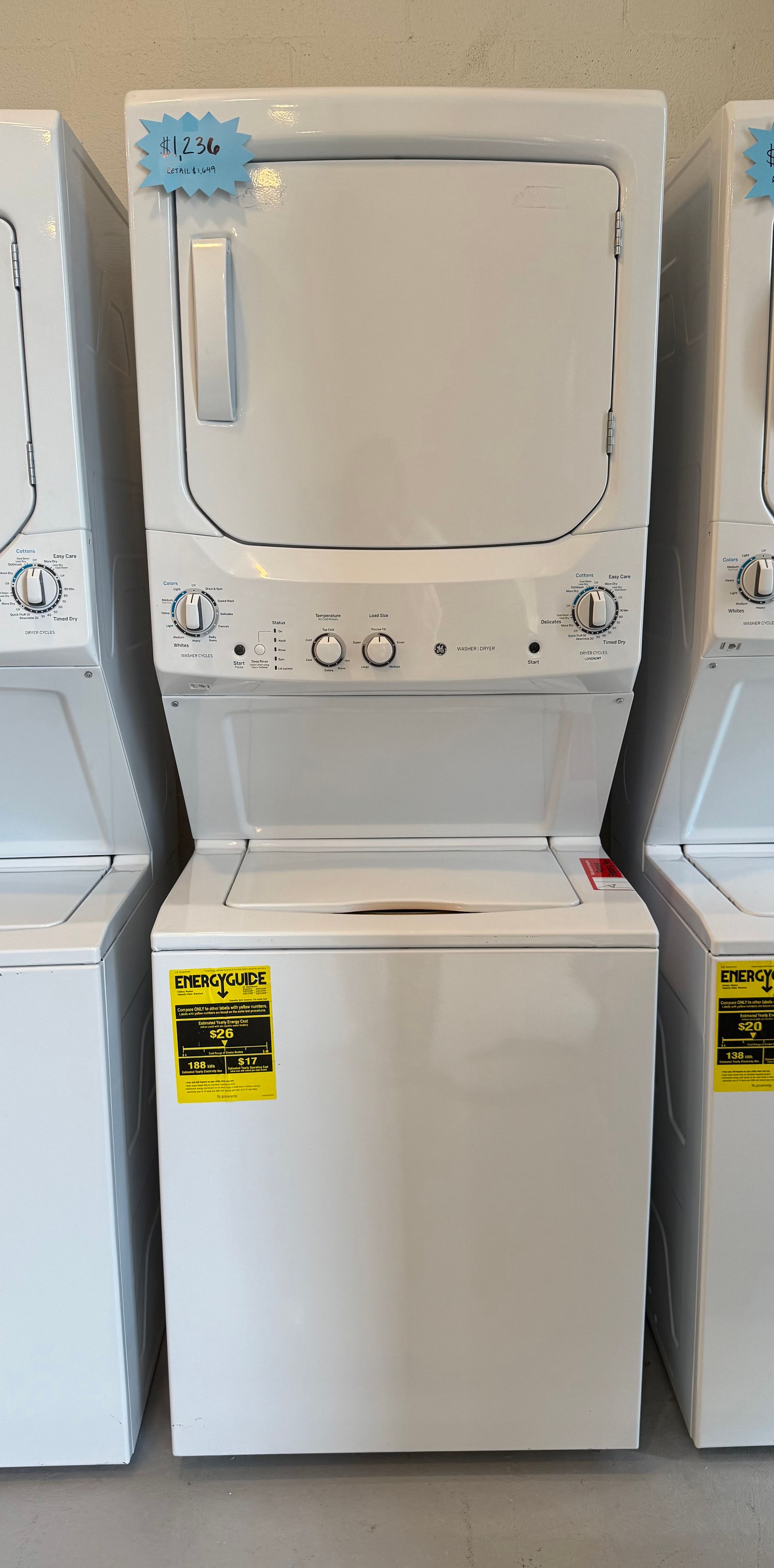 A stacked washer and dryer are sitting next to each other in a laundromat.