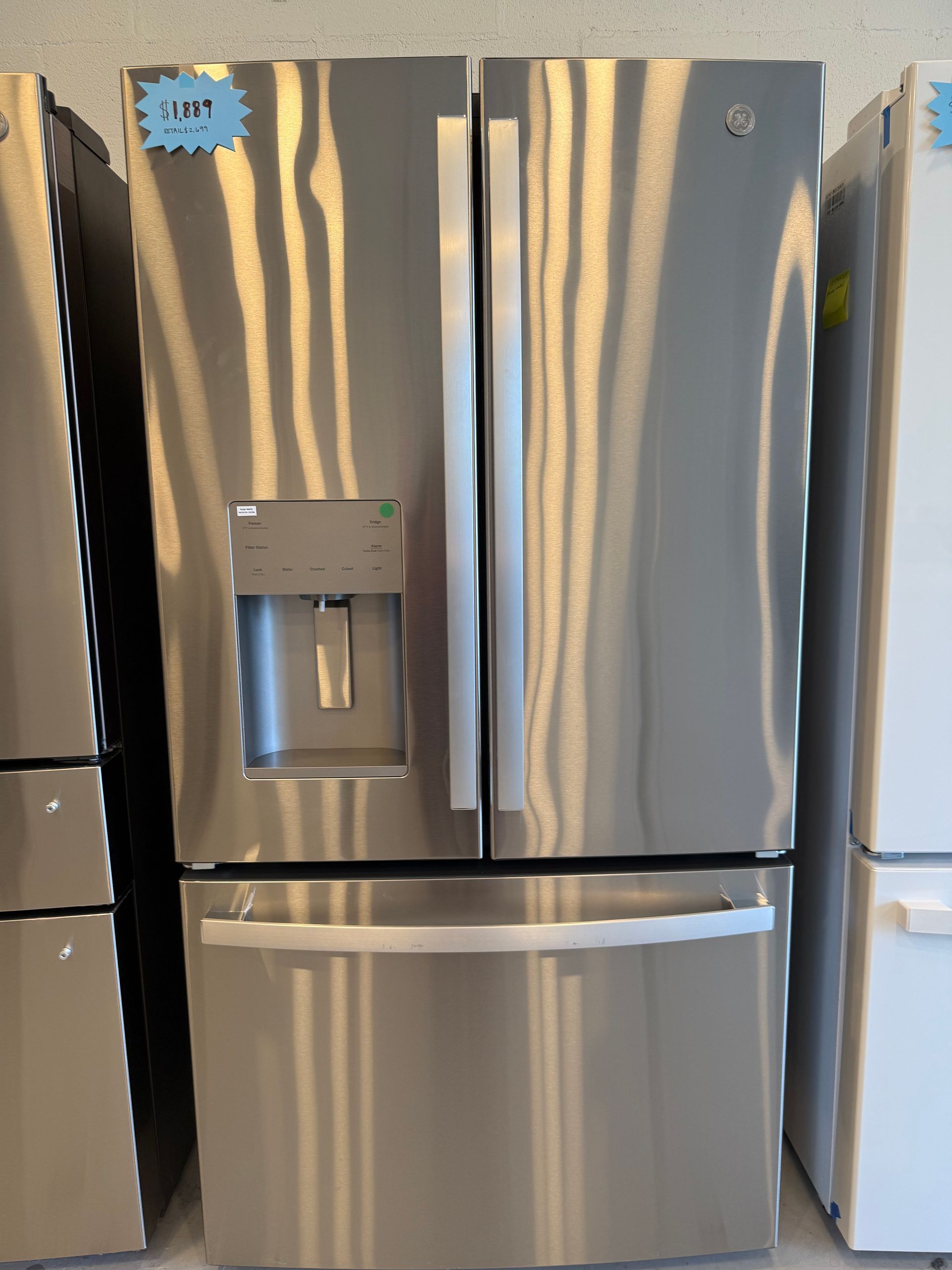 A stainless steel refrigerator with a price tag on it