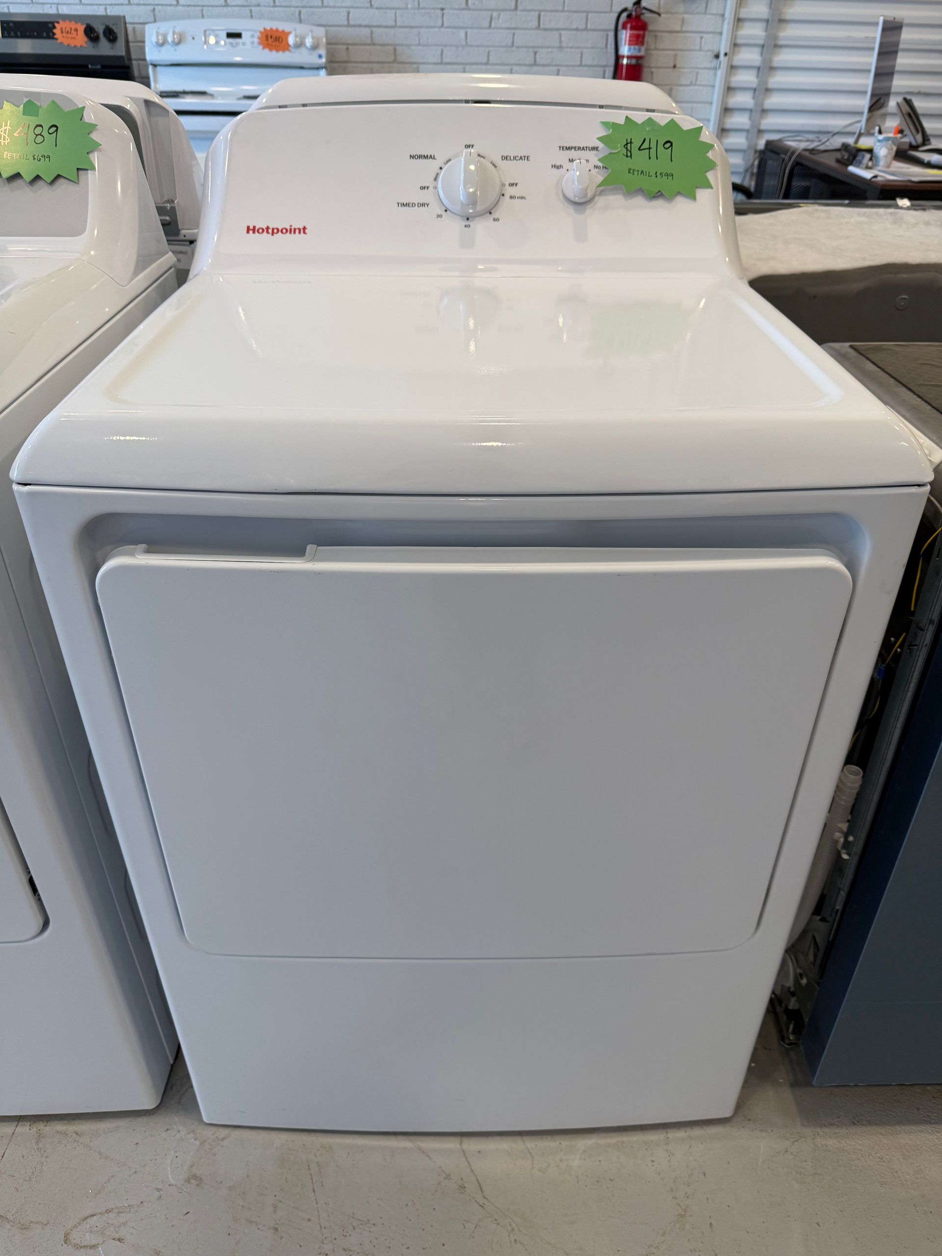 A white dryer with a green price tag on it