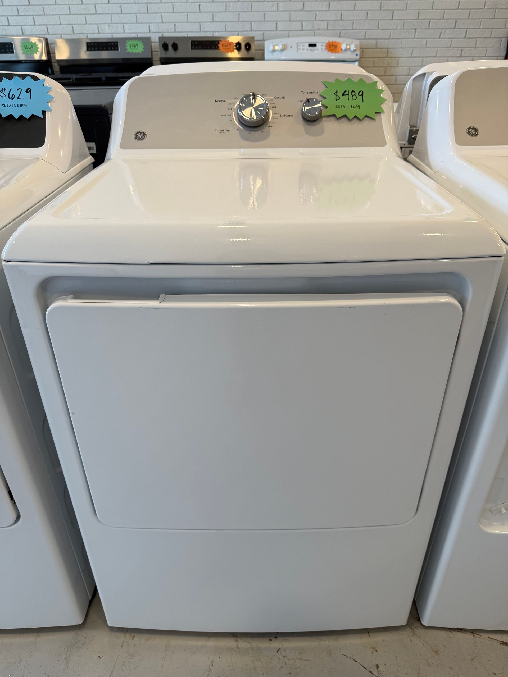 A white dryer with a green price tag on it