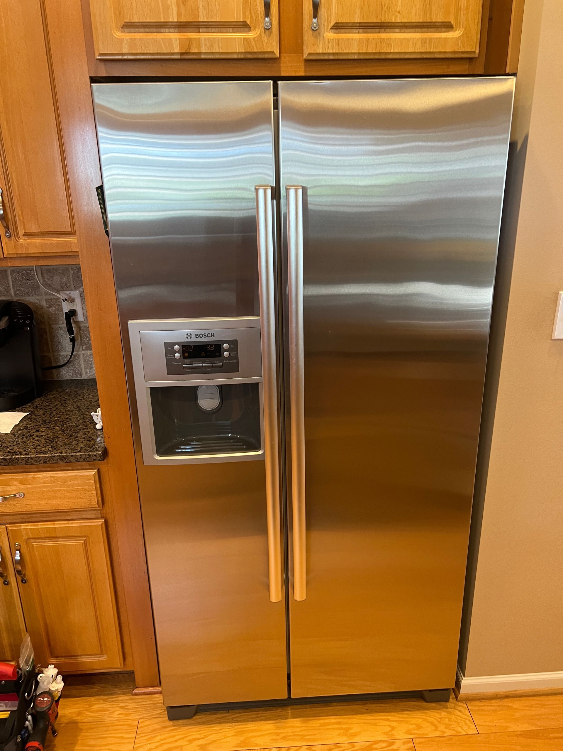 A stainless steel refrigerator is sitting in a kitchen next to a counter.