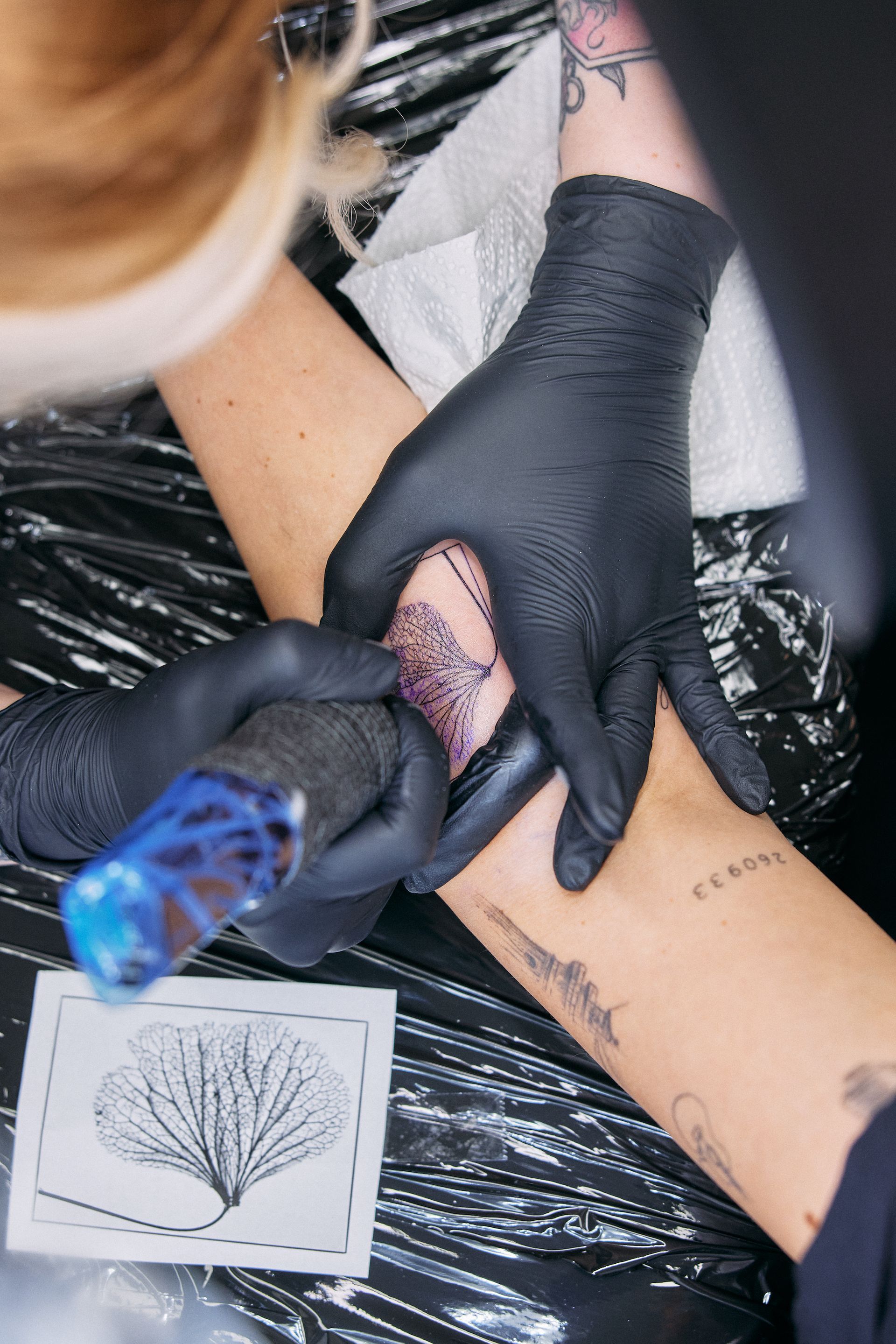 eine Frau bekommt ein Tattoo auf ihrem Arm .