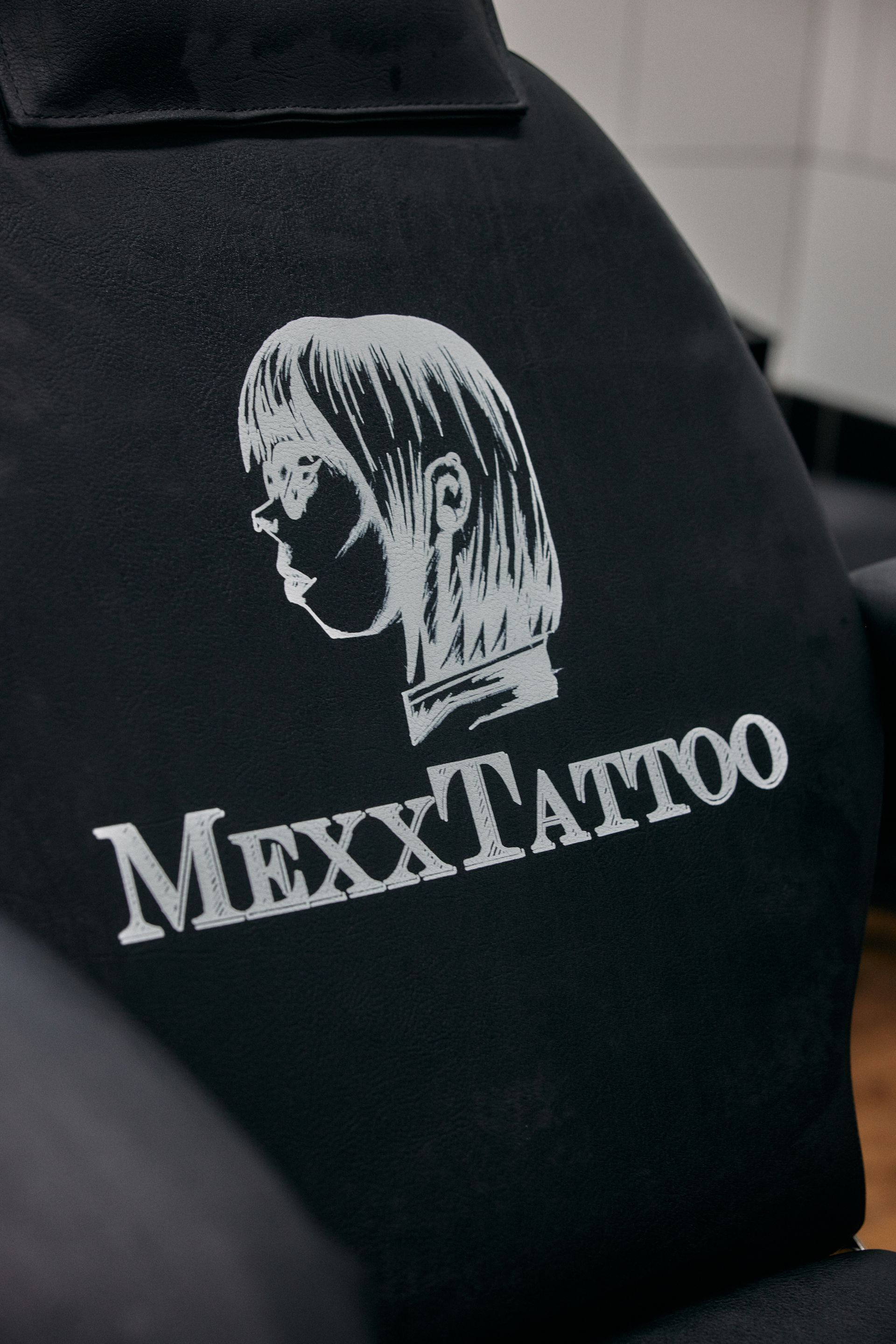 eine schwarze Schürze mit dem Logo mexxtattoo darauf