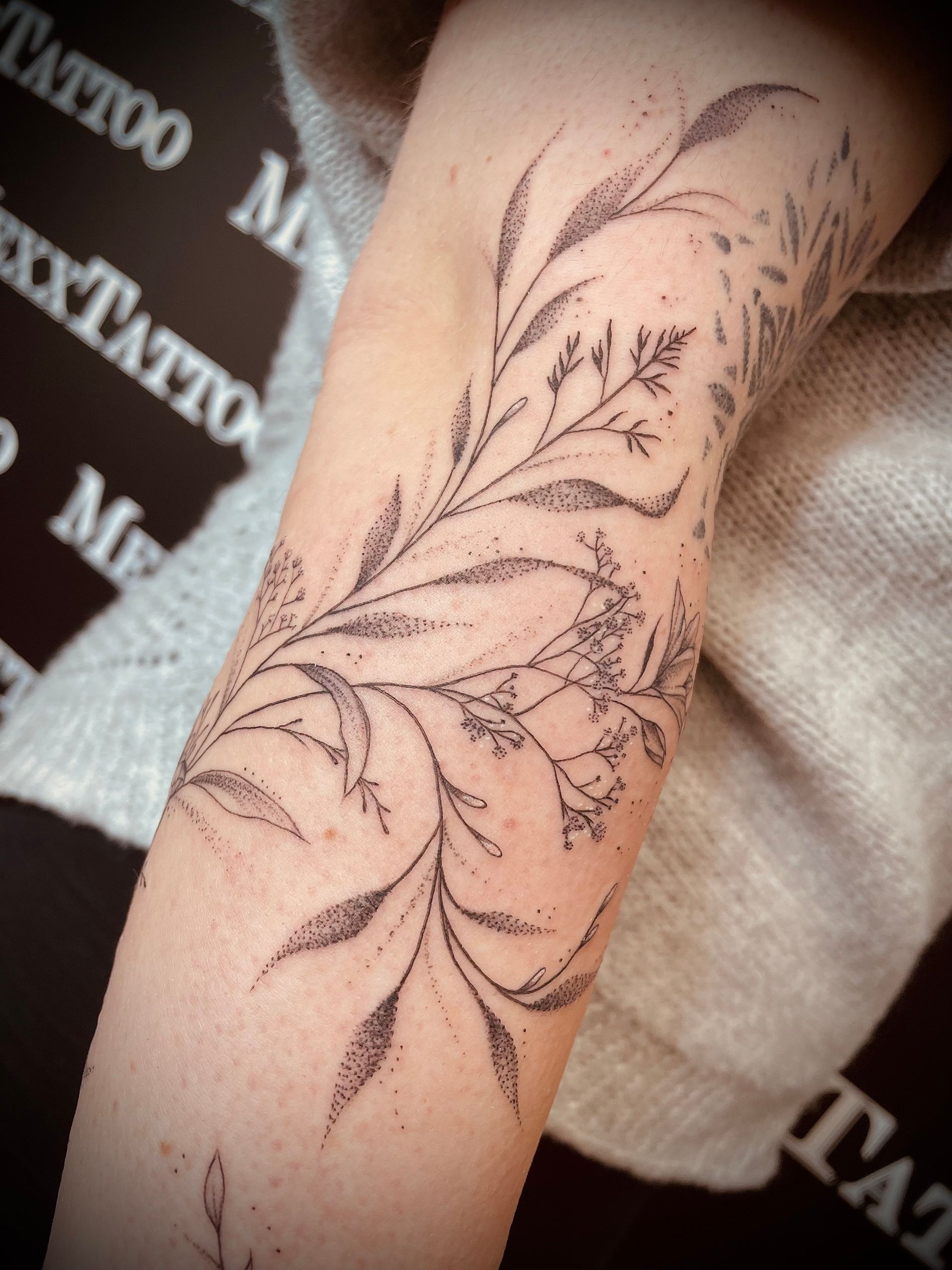 eine Frau mit einem Blumentattoo auf ihrem Arm