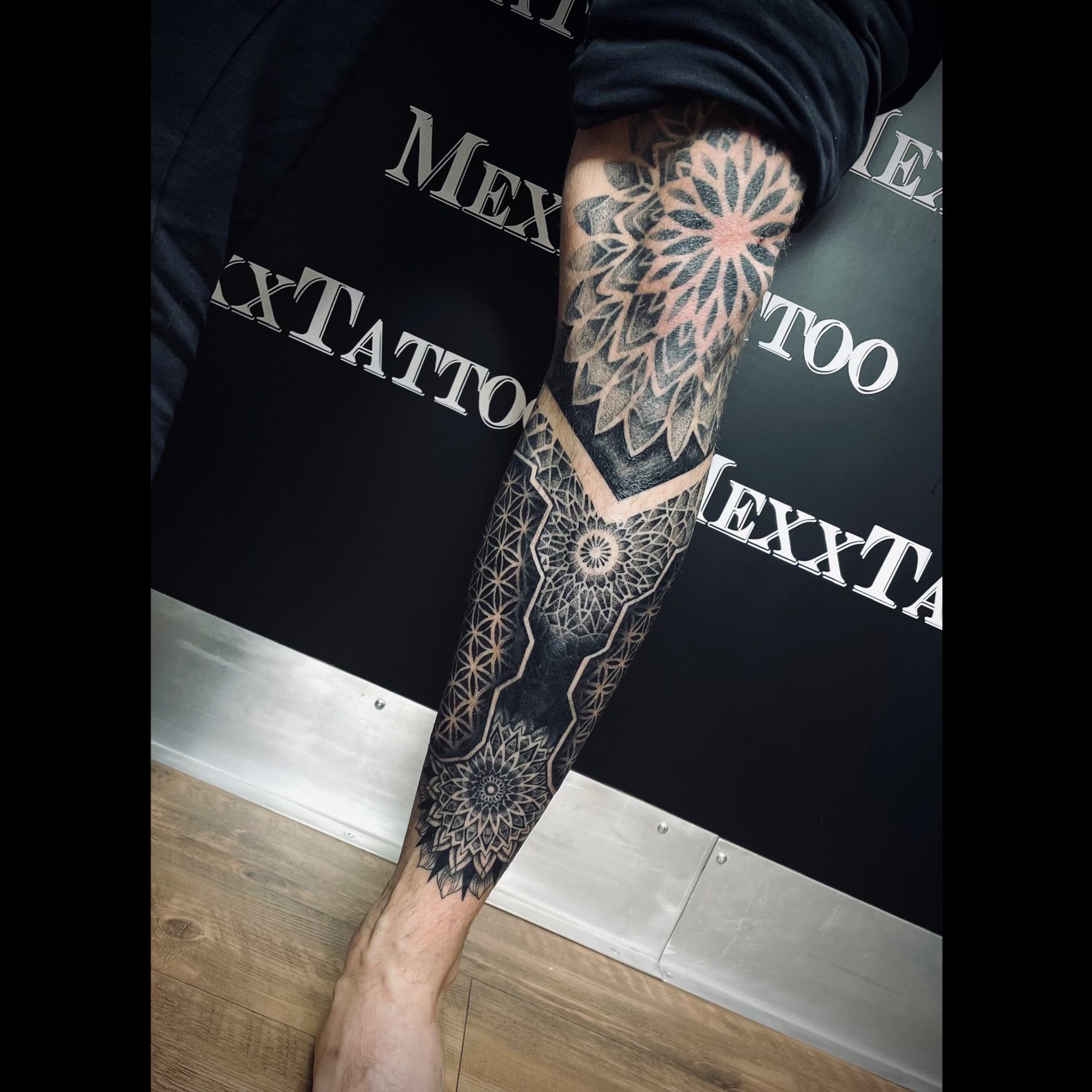 ein Mann mit einem Tätowierungsdesign auf seinem Bein .